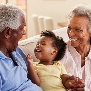 Grandparents smiling and talking to young child