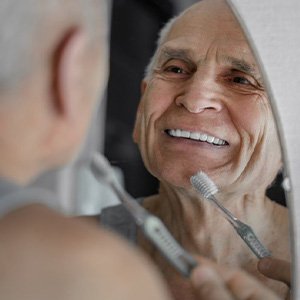 Older man brushing his teeth
