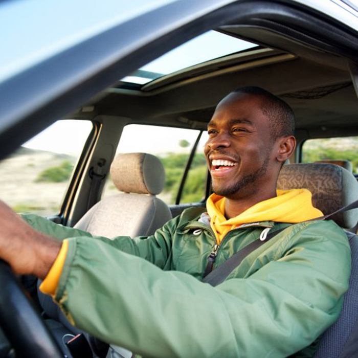 Man smiles while driving