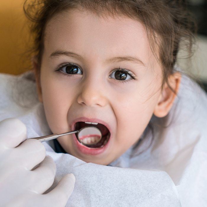 Dentist checking child's smile after dental sealant placement