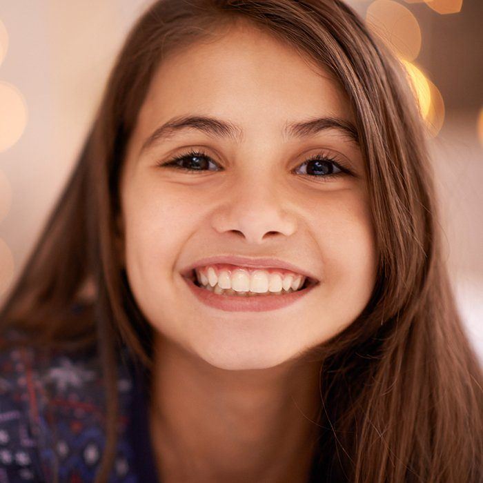 Young girl smiling after pulpotomy treatment