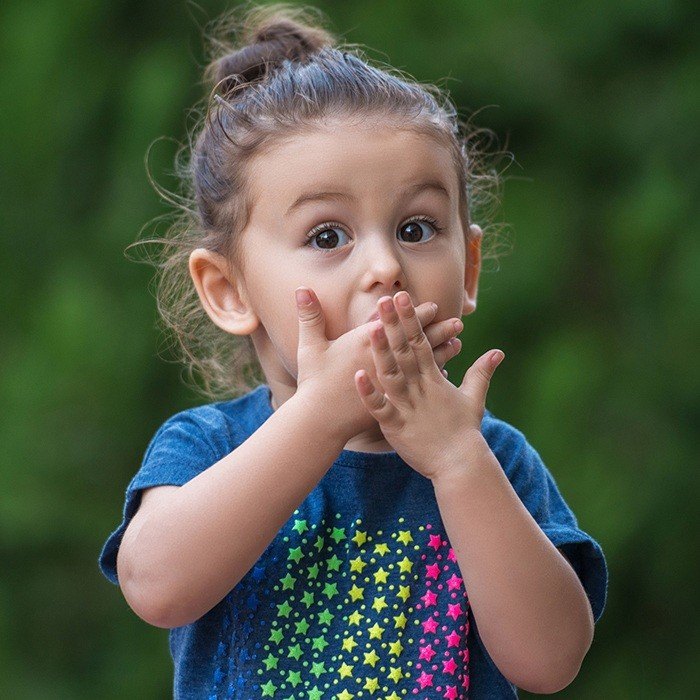 Little girl with broken tooth covering her mouth