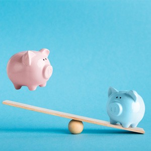 Piggy banks on balance scale 