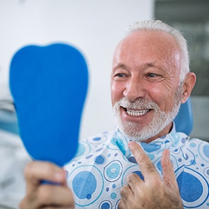 a man checking his dental restorations in a mirror