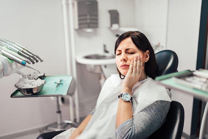 Woman thinking about cost of emergency dentistry in Frisco