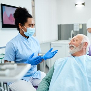 Man smiling and speaking with dentist 