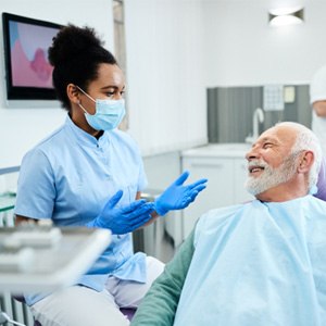 Man smiling and speaking with dentist