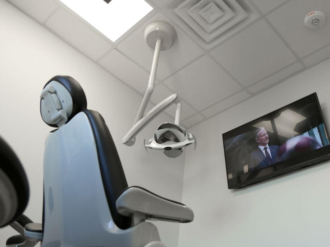 Dental chair and television screen in Frisco dental treatment room