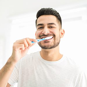 man brushing his teeth in the bathroom