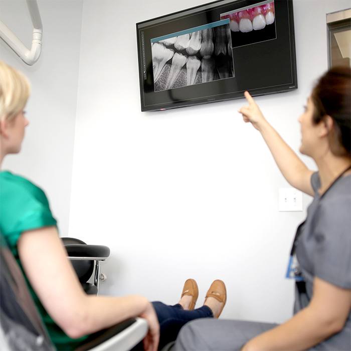 Dentist and patient looking at Nomad digital x-rays
