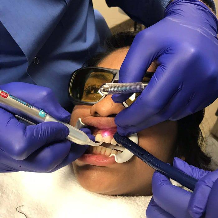 Patient receiving soft tissue laser dentistry