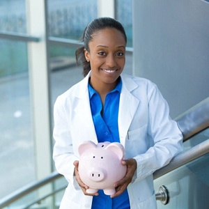 smiling dentist holding a pink piggy bank