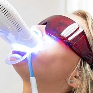 Woman relaxing during in-office teeth whitening treatment