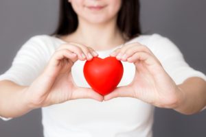 woman holding a red love heart for American Heart Month 