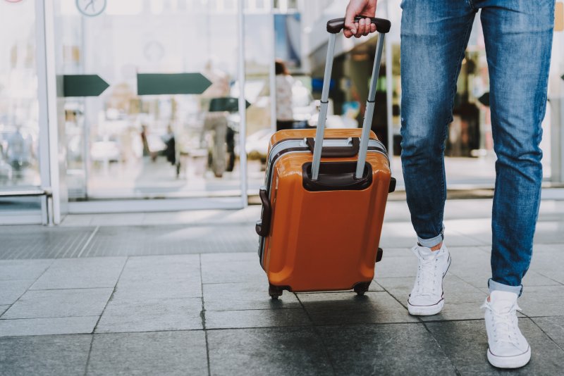 man pulling luggage before trip