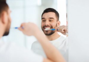 man brushing his teeth with the best toothpaste for veneers 