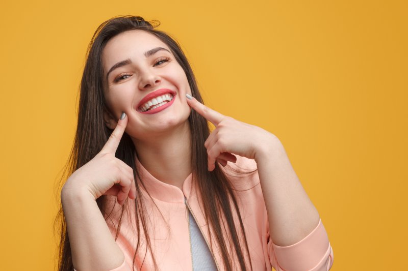 woman smiling about avoiding a dental emergency in Frisco