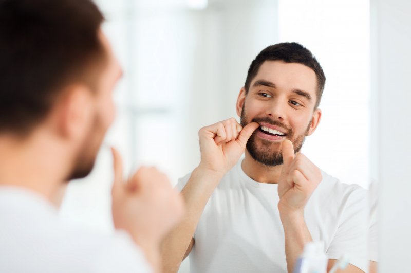 A man flossing his teeth