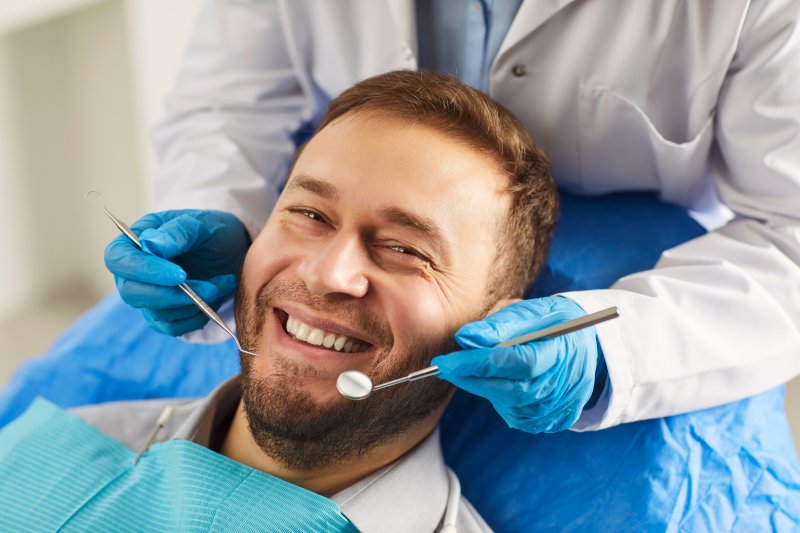 A happy man receiving a dental checkup from his dentist